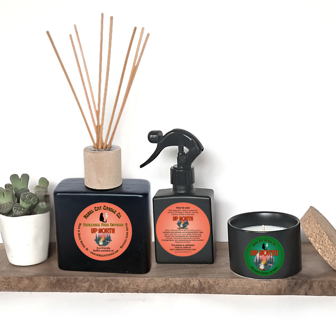 Collection of home fragrance products including a diffuser, spray bottle, and candles on a wooden shelf.