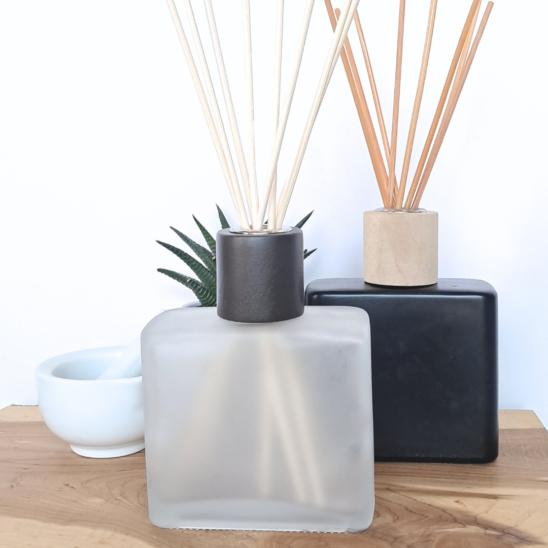 frosted white and matte black square glass bottles with natural reeds