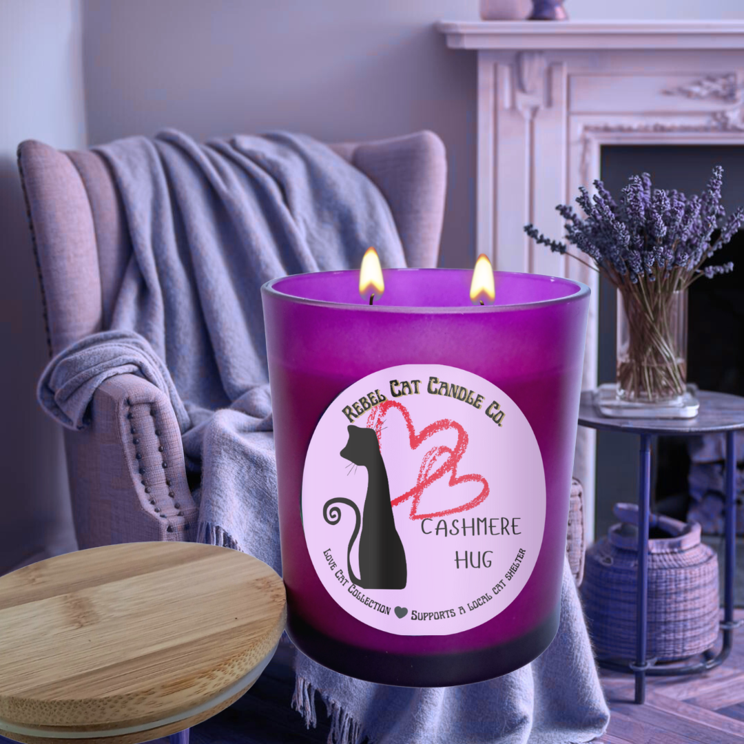 Purple candle with a round label in a cozy living room setting with easy chair, blanket and lavender flowers in a vase